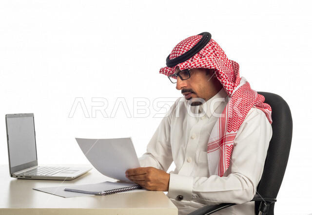 بورتريه لرجل أعمال سعودي خليجي في مقر العمل، استخدام جهاز الحاسوب المحمول لإنجاز المهام والمشاريع، جلسة عمل، العمل عن بعد، مهن وأعمال تجارية، بيئه عمل، التسويق الإلكتروني، مفهوم إدارة الأعمال، عقد صفقات عمل عبر الإنترنت، متابعة إستراتيجية المشروع