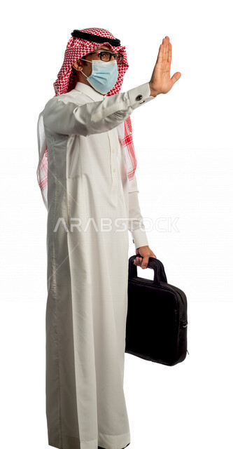 بورتريه لرجل أعمال خليجي سعودي يحمل حقيبة للذهاب إلى العمل بإيماءات وجه ويدين مختلفة، مرتدي القناع الطبي الوقائي للوقاية من فايروس كورونا كوفيد-19، منظر جانبي لرجل سعودي بالزي التقليدي السعودي، إتباع إجراءات الوقاية من الفايروسات، الحفاظ على المسافات