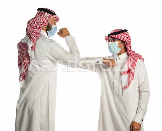 بورتريه لموظفان خليجيان سعوديان يتصافحان بإيماءات يدين مختلفة، إرتداء القناع الطبي الوقائي للوقاية من فايروس كورونا كوفيد-19، زملاء عمل، مفهوم إدارة الأعمال ، إتباع إجراءات الوقاية والحماية من الفيروسات، الحفاظ على المسافات