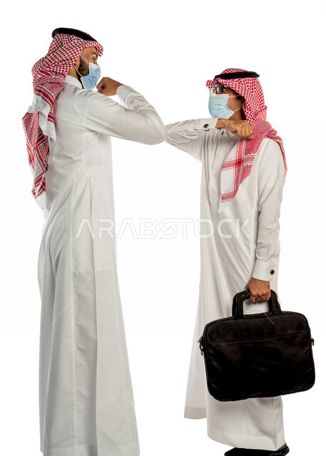 بورتريه لموظفان خليجيان سعوديان يتصافحان بإيماءات يدين مختلفة، إرتداء القناع الطبي الوقائي للوقاية من فايروس كورونا كوفيد-19، زملاء عمل، مفهوم إدارة الأعمال ، إتباع إجراءات الوقاية والحماية من الفيروسات، الحفاظ على المسافات