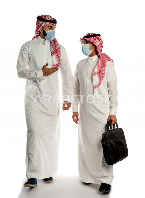 بورتريه لموظفان خليجيان سعوديان، يمشيان بإيماءات وجه ويدين مختلفة، يتناقشان في أمور خاصة بالعمل، إرتداء القناع الطبي للوقاية من فايروس كورونا كوفيد-19، جلسة عمل، أعمال تجارية، مفهوم إدارة الأعمال، متابعة إستراتيجية المشروع ، تحقيق أهداف الشركة، بيئه عمل