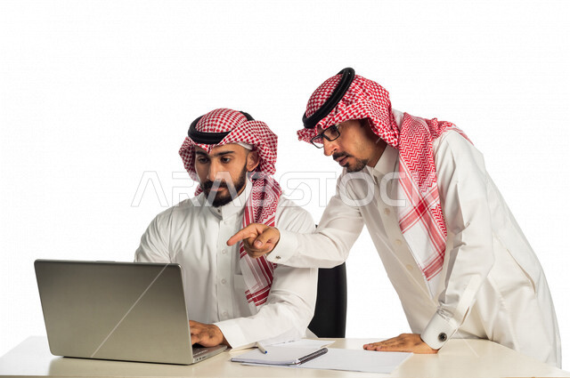 بورتريه لموظفان خليجيان سعوديان في مقر الشركة، إستخدام الحاسوب المحمول لإنجاز المهام، العمل عن بعد، زملاء عمل، شركة سعودية، أعمال تجارية، مفهوم إدارة الأعمال، تحقيق أهداف الشركة، متابعة إستراتيجية العمل، مناقشة المشروع، جلسة عمل، مراجعة البحوث العلمية