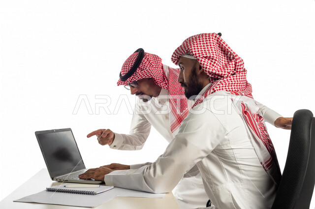 بورتريه لموظفان خليجيان سعوديان في مقر الشركة، إستخدام الحاسوب المحمول لإنجاز المهام، العمل عن بعد، زملاء عمل، شركة سعودية، أعمال تجارية، مفهوم إدارة الأعمال، تحقيق أهداف الشركة، متابعة إستراتيجية العمل، مناقشة المشروع، جلسة عمل، مراجعة البحوث العلمية