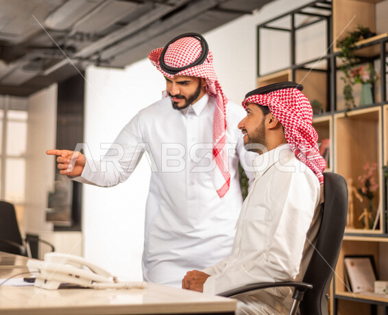 مناقشة عمل بين زميلين عربيين سعوديين خليجيين, اجتماع زملاء عمل في مقر عملهم, توزيع مهام العمل, بيئة العمل السعودي, الوحده والعمل الجماعي, تحقيق اهداف الشركه, تطوير العمل وحل المشكلات