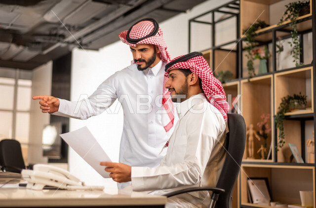 مناقشة عمل بين زميلين عربيين سعوديين خليجيين, اجتماع زملاء عمل في مقر عملهم, توزيع مهام العمل, بيئة العمل السعودي, الوحده والعمل الجماعي, تحقيق اهداف الشركه, تطوير العمل وحل المشكلات