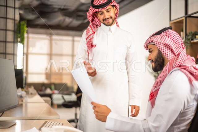 مناقشة عمل بين زميلين عربيين سعوديين خليجيين, اجتماع زملاء عمل في مقر عملهم, توزيع مهام العمل, بيئة العمل السعودي, الوحده والعمل الجماعي, تحقيق اهداف الشركه, تطوير العمل وحل المشكلات