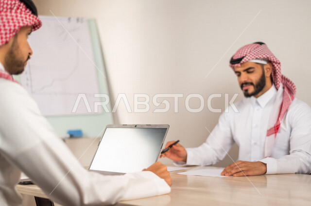 Meeting of Saudi-Arab Gulf co-workers at their workplace, discussing work tasks, Saudi work environment, unity and teamwork, achieving company goals, developing and solving problems