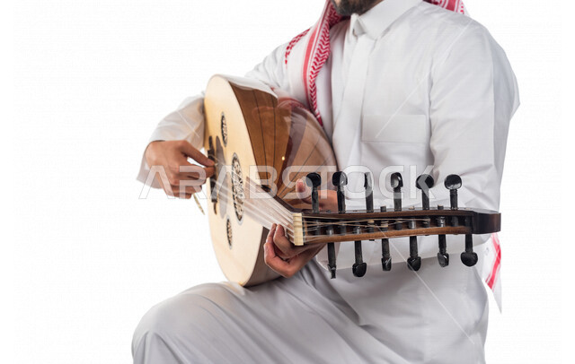صورة مقربة لرجل عربي سعودي خليجي يعزف على آلة العود , آلات موسيقية , مواهب فنية , فنون موسيقية .