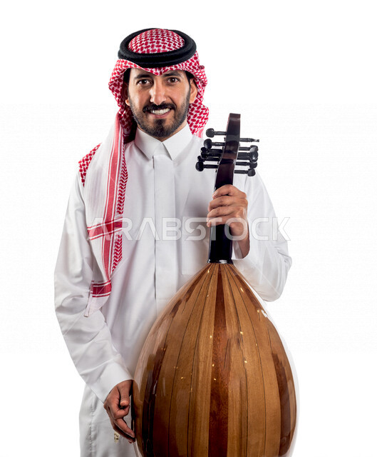 صورة مقربة لرجل عربي سعودي خليجي يحمل بين يديه آلة العود , آلات موسيقية , مواهب فنية , فنون موسيقية .