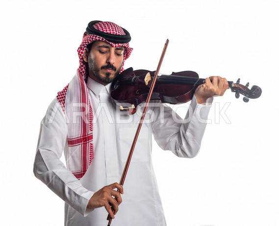 صورة مقربة لرجل عربي سعودي خليجي يعزف على آلة الكمان, آلات موسيقية ,  مواهب فنية , فنون موسيقية .