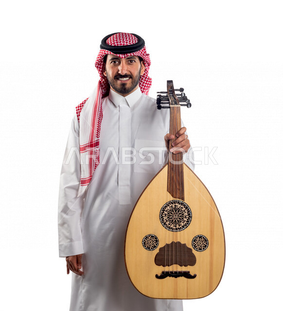 صورة مقربة لرجل عربي سعودي خليجي يحمل بين يديه آلة العود , آلات موسيقية , مواهب فنية , فنون موسيقية .