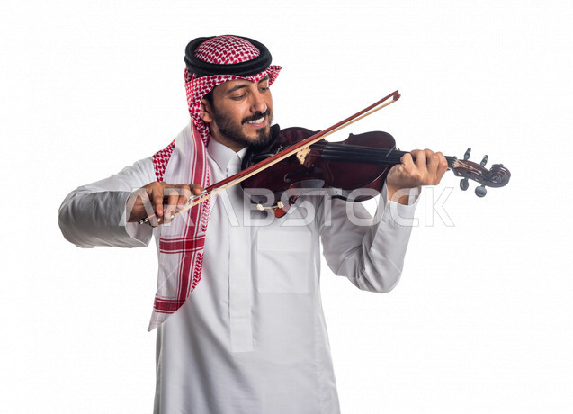 صورة مقربة لرجل عربي سعودي خليجي يعزف على آلة الكمان, آلات موسيقية ,  مواهب فنية , فنون موسيقية .
