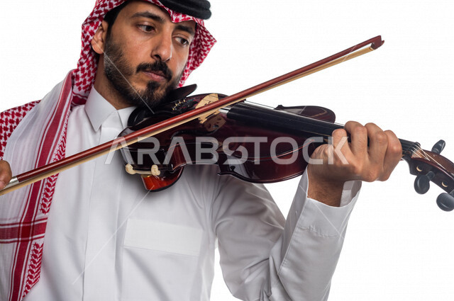 صورة مقربة لرجل عربي سعودي خليجي يعزف على آلة الكمان, آلات موسيقية ,  مواهب فنية , فنون موسيقية .