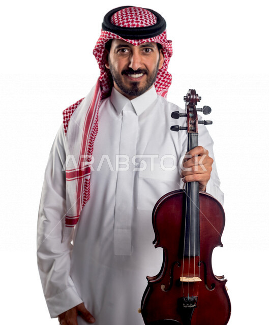 صورة مقربة لرجل عربي سعودي خليجي يحمل بين يديه آلة الكمان, آلات موسيقية ,  مواهب فنية , فنون موسيقية  .