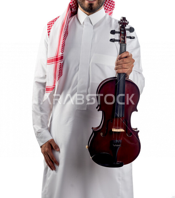 صورة مقربة لرجل عربي سعودي خليجي يحمل بين يديه آلة الكمان, آلات موسيقية ,  مواهب فنية , فنون موسيقية  .