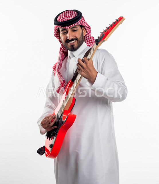 بورتريه لرجل عربي سعودي خليجي يقوم بالعزف على آلة الجيتار الكهربائي، آلات موسيقية، مواهب فنية، فنون موسيقية.