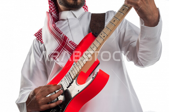 صورة مقربة لرجل عربي سعودي خليجي يقوم بالعزف على آلة الجيتار الإلكتروني , آلات موسيقية , مواهب فنية , فنون موسيقية .