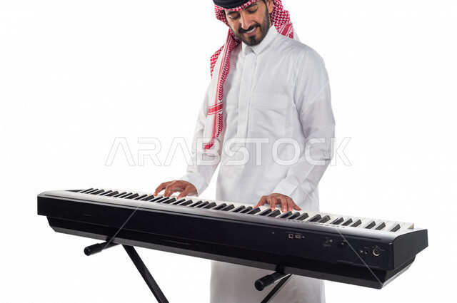 بورتريه لرجل عربي سعودي خليجي يقوم بالعزف على آلة البيانو , آلات موسيقية , مواهب فنية , فنون موسيقية .