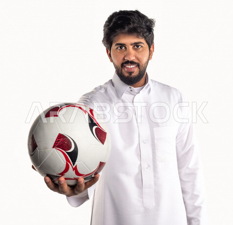 بورتريه لشاب عربي خليجي سعودي، مشجع لفريق سعودي يمسك بيده كرة قدم، ايماءات وجه ويدين مختلفتين