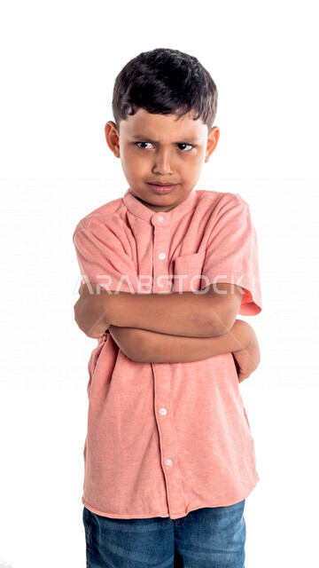 Portrait of a Saudi Gulf boy with folded hands, facial and hands gestures indicating anger, white background