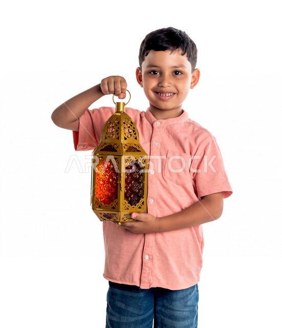 بورتريه لفتى خليجي سعودي مبتسم وسعيد ، يحمل بيده فانوس رمضان، رمضان كريم ، شهر العبادة ، خلفية بيضاء