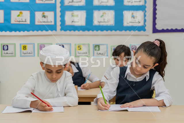 أساليب التعلم الحديثة، موسم العودة إلى المدارس, أهداف التربية والتعليم في المملكة العربية السعودية، طلاب عربيين خليجيين إماراتيين يجلسون على المقاعد داخل الصف ويكتبون واجباتهم المدرسية، تنمية المهارات الإبداعية، مفهوم الاجتهاد والتفوق