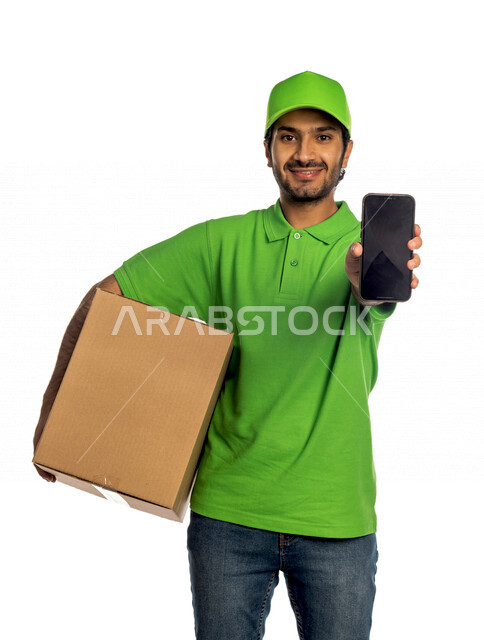 Portrait of a Saudi Arabian Gulf man wearing a green hat working in the delivery of orders and goods to customers, online shopping, online orders, smart shopping, reliable shipping and delivery, delivery representative