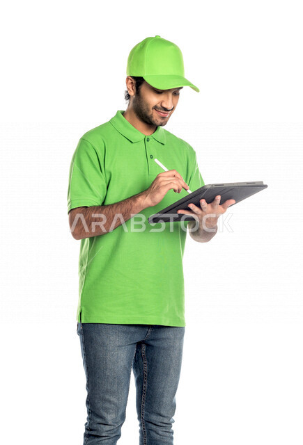 Portrait of a Saudi Arabian Gulf man wearing a green hat working in the delivery of orders and goods to customers, online shopping, online orders, smart shopping, reliable shipping and delivery process, delivery representative, confirmation of reservation
