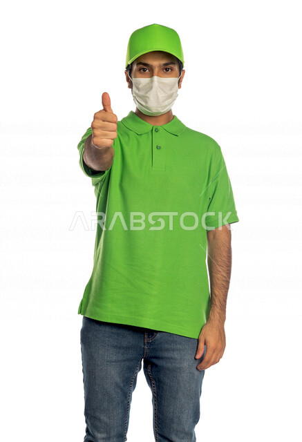 Portrait of a Saudi Arabian Gulf man working in the delivery of orders and goods to customers, online shopping, online orders, smart shopping, reliable shipping and delivery process, delivery representative, commitment to preventive precautions, quality d