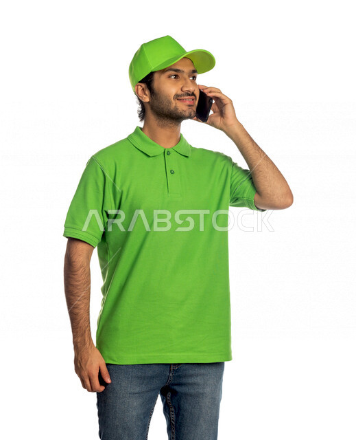 بورتريه لرجل عربي سعودي خليجي يرتدي قبعه خضراء يعمل في توصيل الطلبات والبضائع للزبائن, التسوق الالكتروني, طلبات اونلاين, التسوق الذكي, عملية شحن وتوصيل موثوقه, مندوب توصيل, اجراء المكالمات لتأكيد الحجوزات, التواصل الفعال مع العملاء