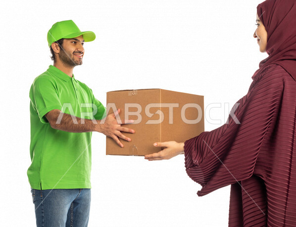 بورتريه لرجل عربي سعودي خليجي يرتدي قبعه خضراء يقوم بتسليم البضائع للزبائن, امراه عربيه سعوديه خليجيه تستلم مشترياتها, التسوق الالكتروني, طلبات اونلاين, التسوق الذكي, عملية شحن وتوصيل موثوقه, مندوب توصيل, امين مخازن