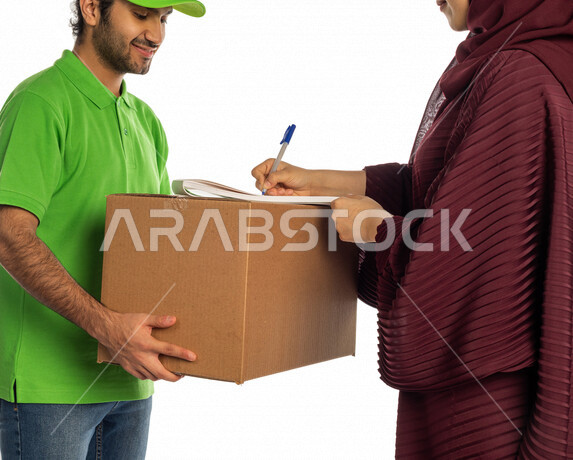 بورتريه لرجل عربي سعودي خليجي يقوم بتسليم البضائع للزبائن, امراه عربيه سعوديه خليجيه تستلم مشترياتها, التسوق الالكتروني, طلبات اونلاين, التسوق الذكي, عملية شحن وتوصيل موثوقه وناجحه, مندوب توصيل, امين مخازن, خدمات التوصيل السريع, توقيع وتأكيد الاستلام