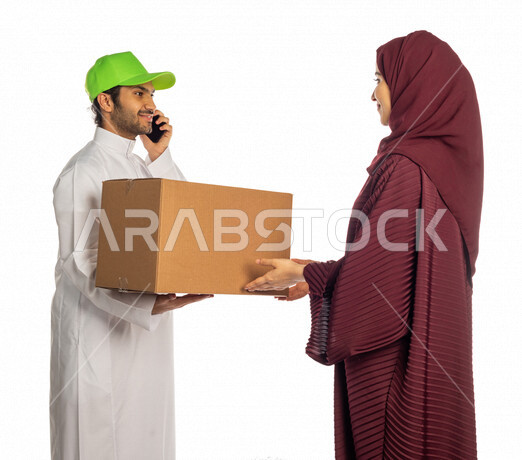 بورتريه لرجل عربي سعودي خليجي يرتدي قبعه خضراء يقوم بتسليم البضائع للزبائن, امراه عربيه سعوديه خليجيه تستلم مشترياتها, التسوق الالكتروني, طلبات اونلاين, عملية شحن وتوصيل موثوقه, مندوب توصيل, اجراء مكالمه هاتفيه لتأكيد الحجوزات ومواعيد الاستلام