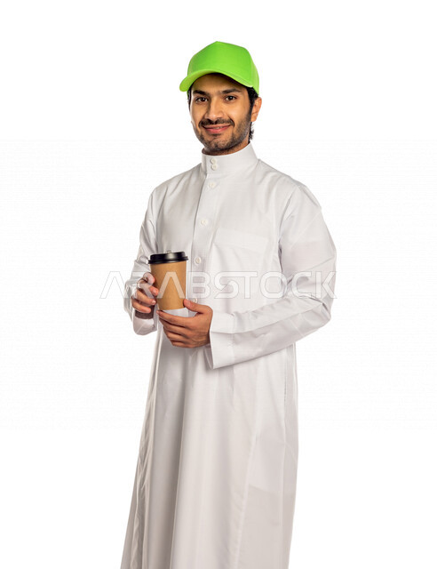 بورتريه لرجل عربي سعودي خليجي يرتدي قبعه خضراء يحمل بيده شراب ساخن , الاستمتاع بالمشروبات الساخنه