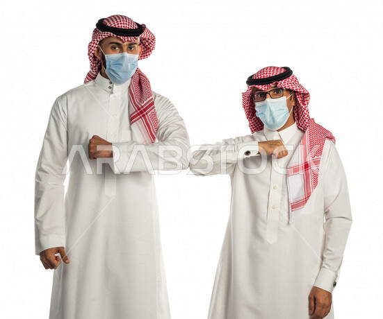 بورتريه لموظفان خليجيان سعوديان يتصافحان بإيماءات يدين مختلفة، المصافحة الأمنة للإلتزام بتعليمات الصحة، إرتداء القناع الطبي الوقائي للوقاية من فايروس كورونا كوفيد-19، زملاء عمل، شركاء عمل ، إتباع إجراءات الوقاية والحماية من الفيروسات، الحفاظ على المسافات