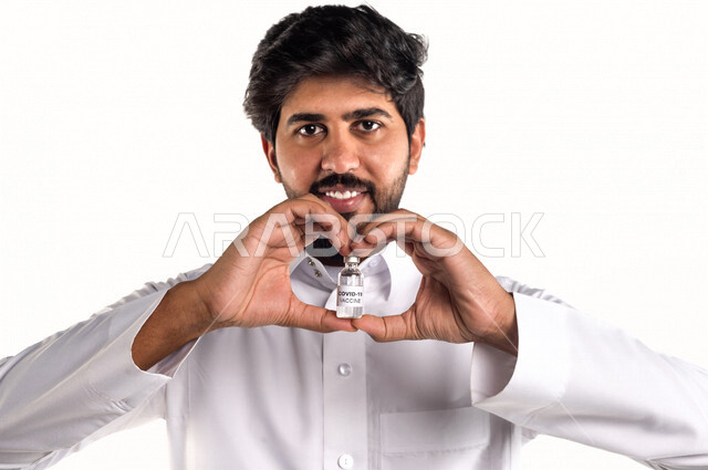 Portrait of a Saudi Arabian Gulf youth holding in his hand a package of the anti-coronavirus (Covid-19) vaccine, vaccinations against diseases, different face and hands gestures, white background