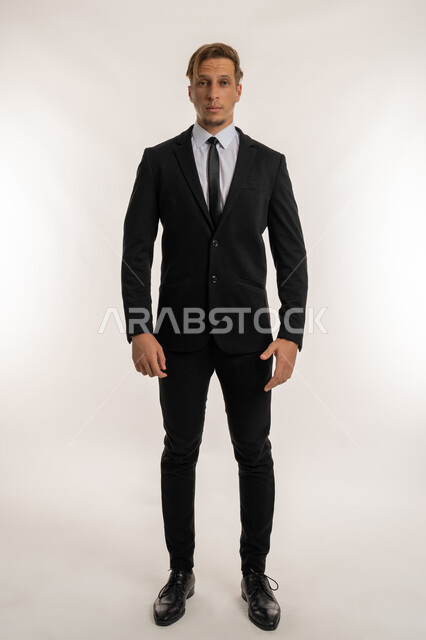 Taking a selfie for official documents, standing straight with self-confident gestures, concept of elegance and masculinity, portrait of a foreign businessman in a formal suit looking at the camera with serious and firm expressions, concern for external appearance, full body length, white backgroun