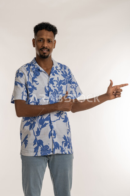 تحديد موقع معين, رجل سعودي يقوم بالدلالة على مكان عنصر، بورتريه لشاب اسمر عربي خليجي اماراتي يرتدي الزي الكاجوال يشير بإصبعيه السبابة إلى شيء ما بايماءات الفرد والتصويب، خلفية بيضاء