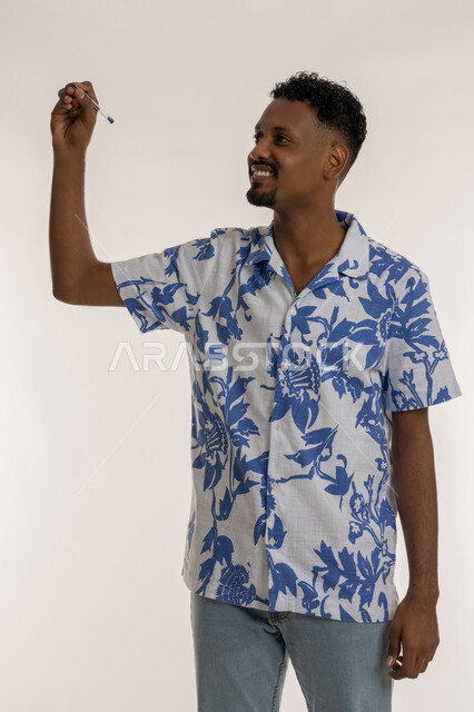 الاستعداد لتدوين وتحديد شيء ما، بورتريه لرجل اسمر عربي خليجي إماراتي يرتدي الزي الكاجوال يمسك بيده قلم يرفع يده بايماءات الكتابة، رجل سعودي يقوم بالرسم والتخطيط والإشارة على الهواء، خلفية بيضاء