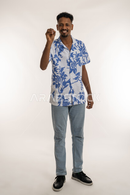Preparing to write down and specify something, looking at the camera with expressions of joy and happiness, portrait of a dark-skinned Arab Gulf Emirati man wearing casual clothes holding a pen in his hand raising his hand with writing gestures, a Saudi man drawing, planning and pointing on air, full body photo, white background
