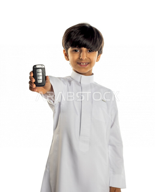 Portrait of a Saudi Gulf boy holding a car remote control in his hand, different facial and hands expressions, white background