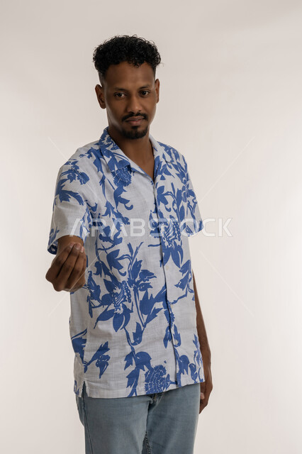 طلب الإنتظار والهدوء، بورتريه لرجل عربي خليجي إماراتي يرتدي الزي الكاجوال يرفع يده بإيماءات الصبر والتأن والتريث، إمهال الوقت للقيام بشيء ما، شاب سعودي يقوم بحركة يد وإشارات، خلفية بيضاء