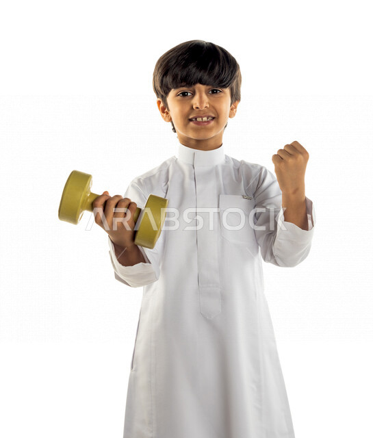 Portrait of a Saudi Arabian Gulf child exercising vigorously and vigorously, carrying weights and weights, losing calories, carrying weights, a sporting activity to maintain fitness and good health, facial and hand gestures that indicate enthusiasm and re