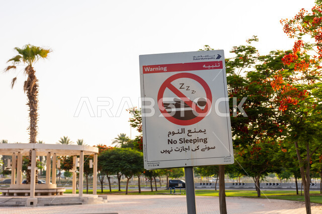 الاهتمام الاشجار والنباتات، صورة مقربة للافتة تحذيرية لممنوع النوم في الحدائق العامة في مدينة دبي، المساحات الخضرات في الامارات العربية المتحدة, أماكن سياحية ترفيهية طبيعية