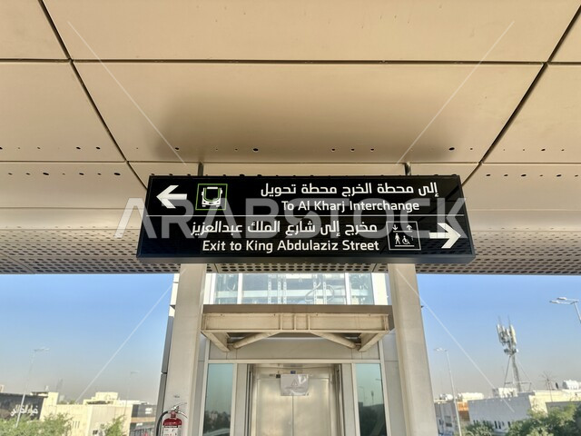 وسائل النقل البرية السريعة الحديثة, لافتة ارشادية باللغتين العربية والانجليزية داخل محطة حافلات في مدينة الرياض، توفير التسهيلات والخدمات في السعودية، استخدام اللافتات الدلالية واللوحات الارشادية، مفهوم المواصلات العامة، مخرج الى شارع الملك عبد العزيز