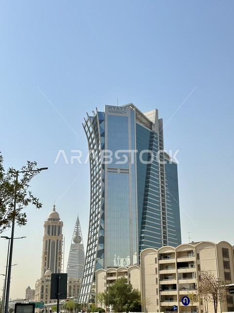 Distinctive architectural engineering art in the design of the Hyatt Regency Hotel in Riyadh, urban growth and development in the Kingdom of Saudi Arabia, luxury hotels and tourist resorts, the concept of tourism in the Gulf countries, towering towers and skyscrapers, clear blue sky background