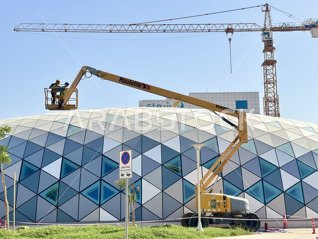 الفن الهندسي المعماري في التصميم الفريد والحديث لمحطة الورود في العاصمة الرياض، الاهتمام بالخدمات العامة ووسائل النقل، تصوير لرافعة وعمال عربيين خليجيين سعوديين يقومون بتنظيف السطح، التطوير والتقدم الحضاري وتحسين البنية التحتيه، محطات المترو والقطار السريع