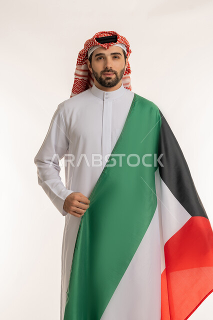 الاحتفال بالمناسبات والأعياد الوطنية, اظهار مشاعر الفخر بالانتماء للوطن, بورتريه لشاب عربي خليجي كويتي يرتدي الثوب التقليدي والشماغ ينظر إلى الكاميرا باعتزاز, استذكار اليوم الوطني الكويتي في 25 فبراير, الاخلاص والولاء للبلاد، خلفية بيضاء