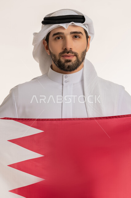Celebrating Qatar National Day December 18, commemorating the founding of the state, close-up portrait of a Qatari Gulf Arab man holding the Qatari flag with gestures of pride and honor, national symbols and cultures, love of the homeland and belonging to it, white background