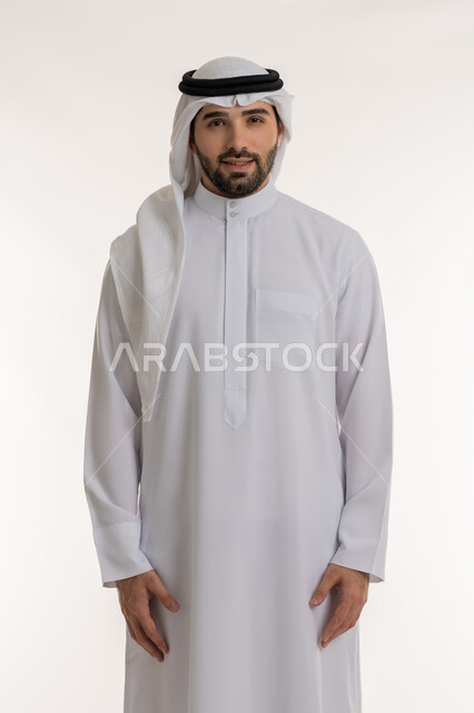 الأناقة والاهتمام بالمظهر الخارجي، التقاط الصور الشخصية للوثائق الرسمية، بورتريه لشاب عربي خليجي سعودي يرتدي الثوب التقليدي والغترة ينظر الى الكاميرا بتعابير البشاشة، الوقوف باستعداد واستقامة، مفهوم الرجولة والثقة بالنفس، خلفية بيضاء